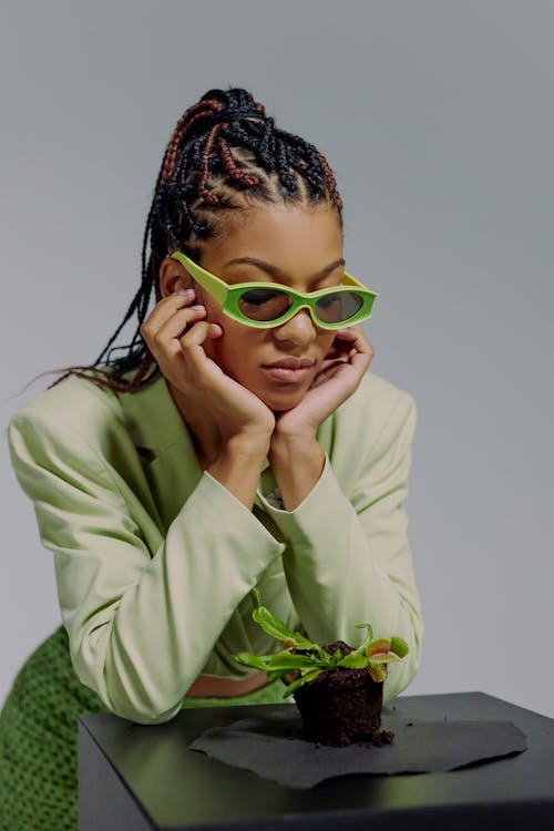 Free Woman in green sunglasses looking at Venus flytrap Stock Photo