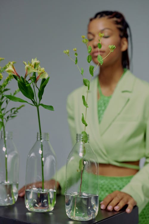 Studio shot of woman and plants in vases