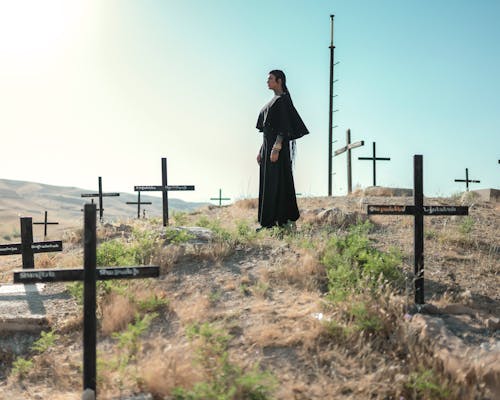 Woman in a Black Gown Among the Graves in the Cemetery