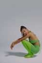 Portrait of crouching woman in green clothes