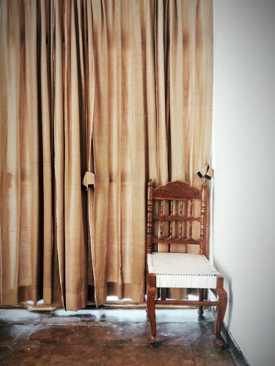 Brown And White Wooden Chair Beside A Brown Window Curtain
