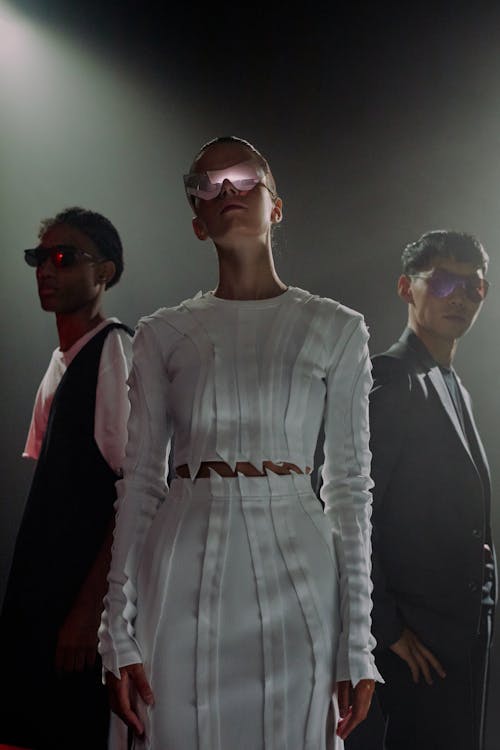 Three people in sunglasses against black background