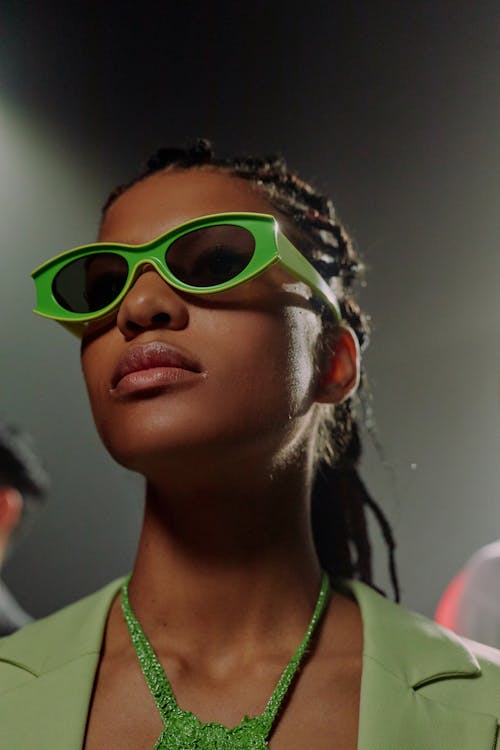 Studio portrait of woman in green sunglasses