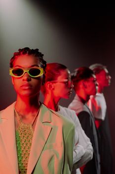 Fashionable group portrait with unique eyewear and dramatic studio lighting.