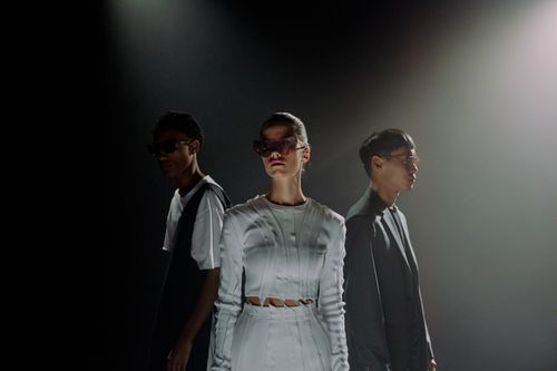 Free Stylish models wearing sunglasses posing in a studio with dramatic lighting. Stock Photo