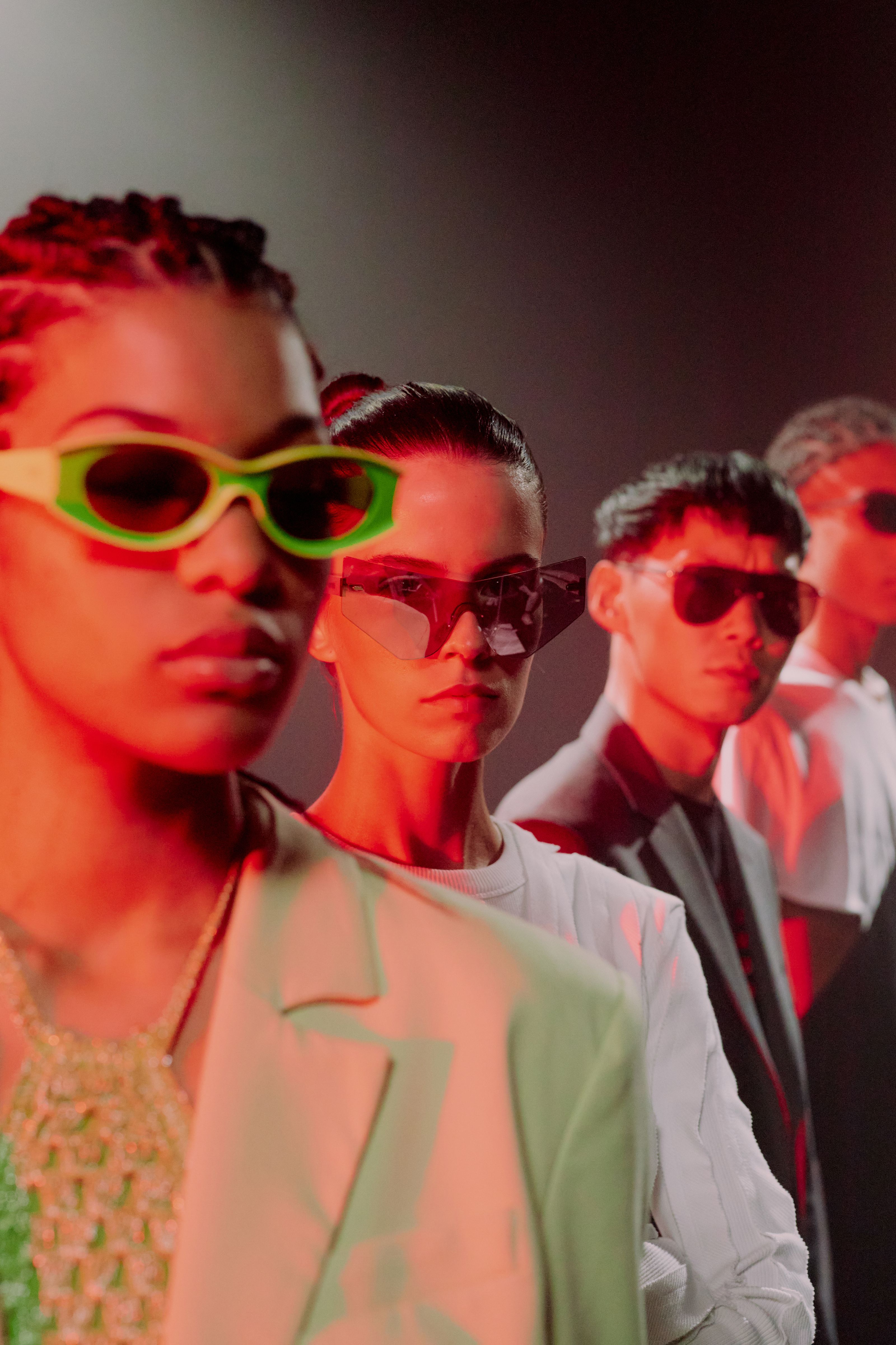 Grupo estiloso com óculos de sol coloridos exibindo tendências da moda.