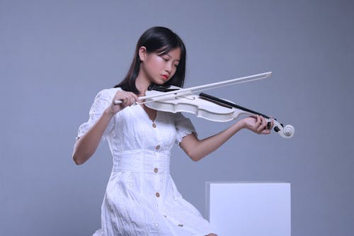 Woman in White Dress Playing Violin