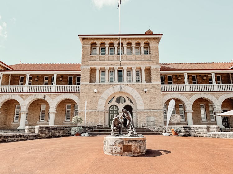 A Statue In Front Of A Mansion