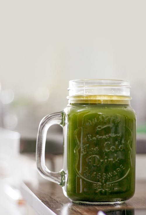 A Clear Glass Mug With Green Liquid Inside