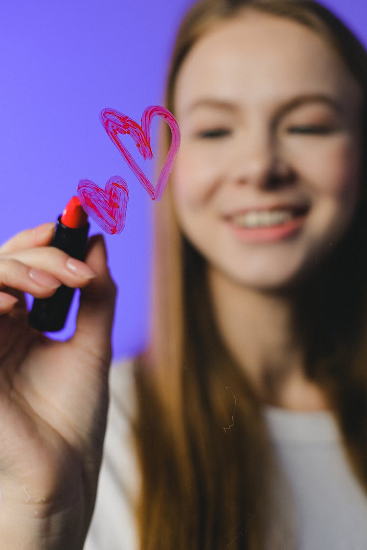 Teenager Drawing Heart Symbol On Glass