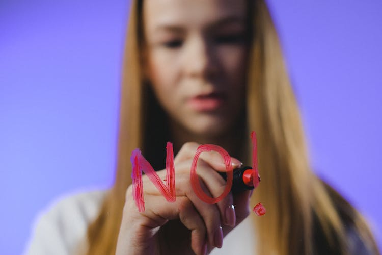 Studio Shot Of Girl Writing No Word On Glass