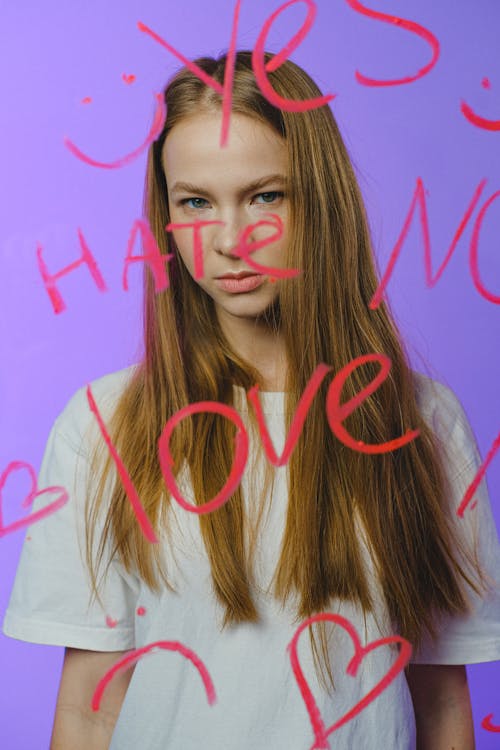 Teenage girl behind glass with various words