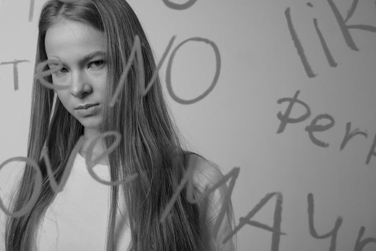 Black And White Portrait Of Girl Behind Glass With Words