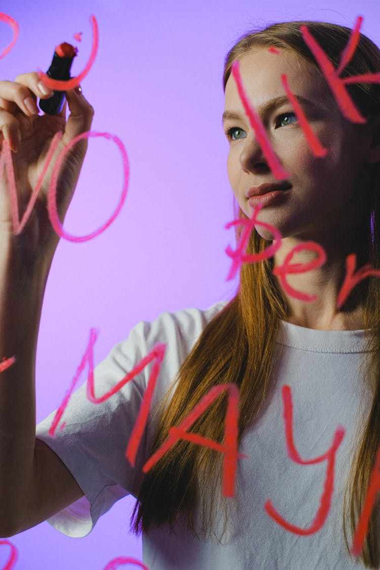 Teenage Girl Writing Words On Glass