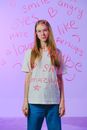 Studio portrait of girl behind words on glass