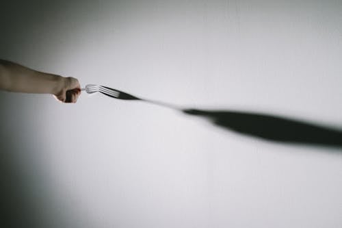 Person touching wall with fork