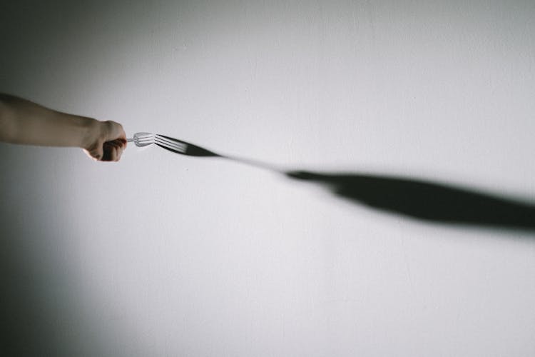 Person Touching Wall With Fork