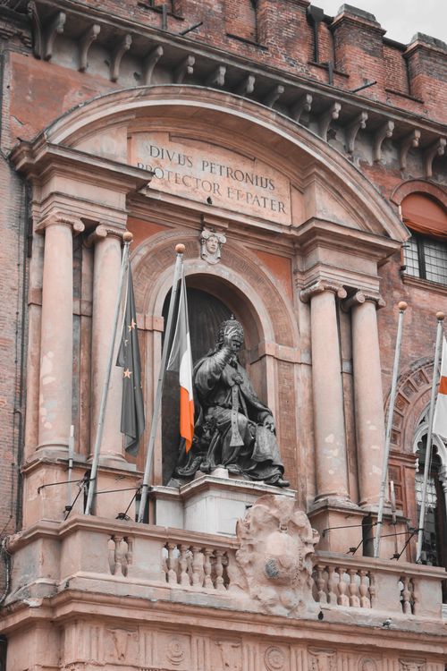 Free Vertical shot of a historical statue with flags in Bologna, Italy. Stock Photo