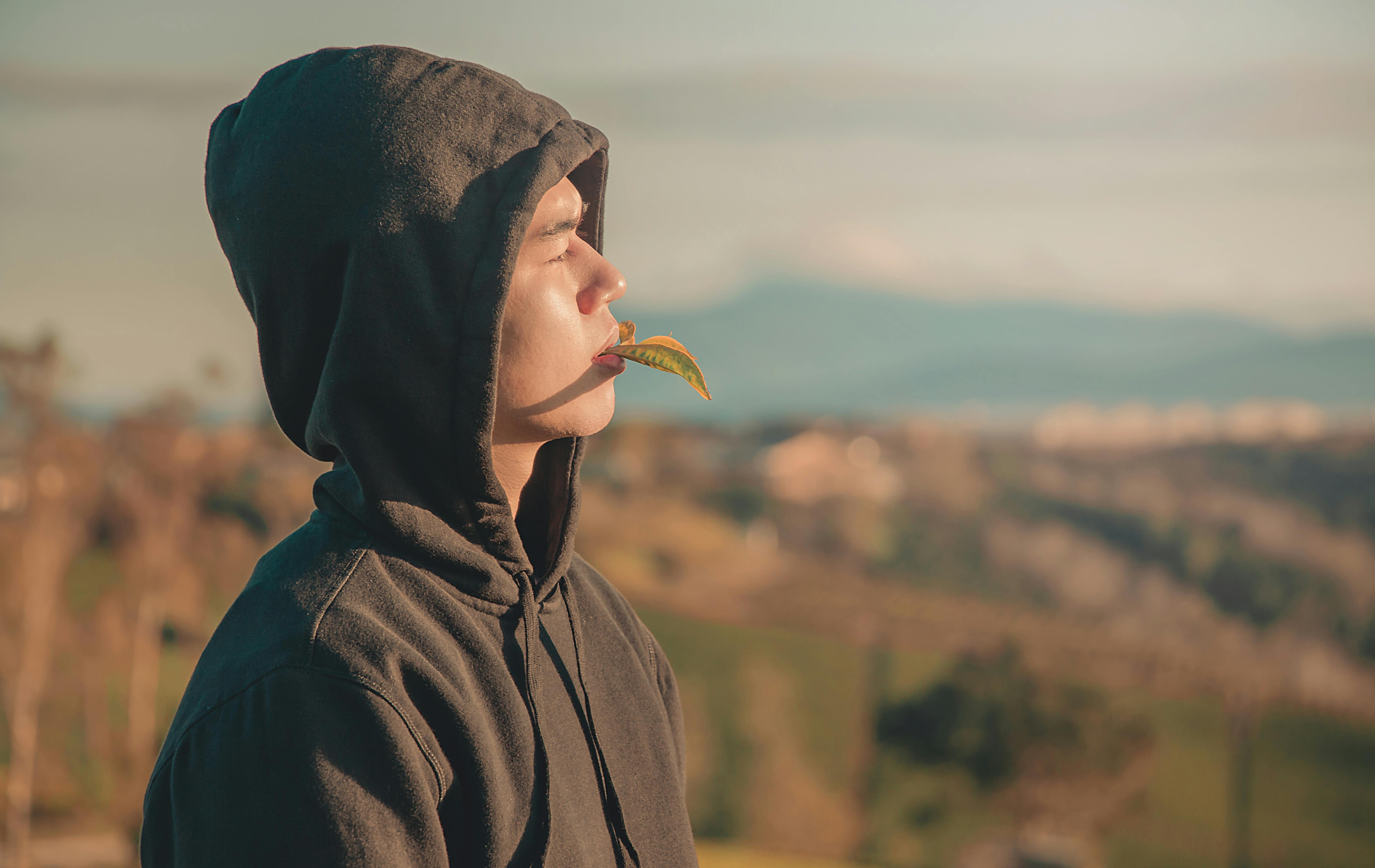 Download Man in Black Hoodie Standing in Front of Body of Water · Free Stock Photo