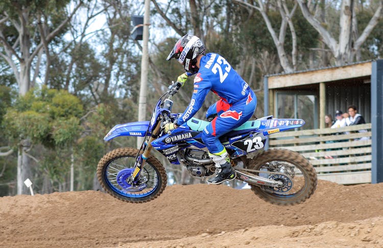 A Person Riding A Motocross Bike Doing Tricks On A Muddy Trail