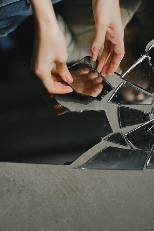 Woman touching broken mirror