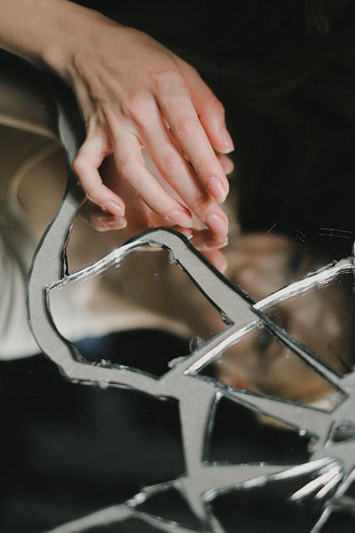 Woman touching broken mirror