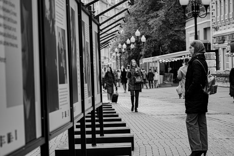 Woman Reading Information From Boards In A Street