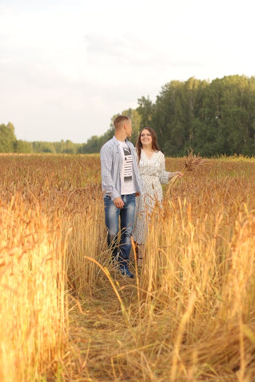 A Couple Walking on a Grass Field