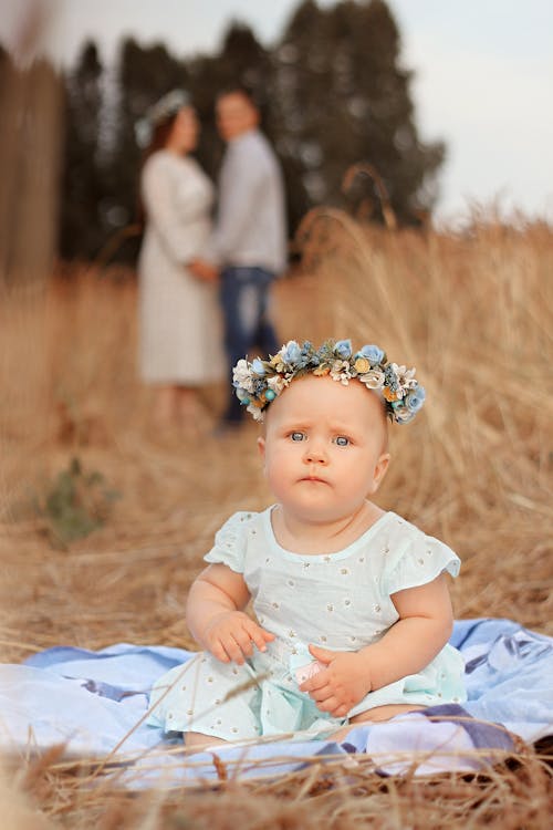 Toddler in a Flower Crown Sitting in a Wheat Field