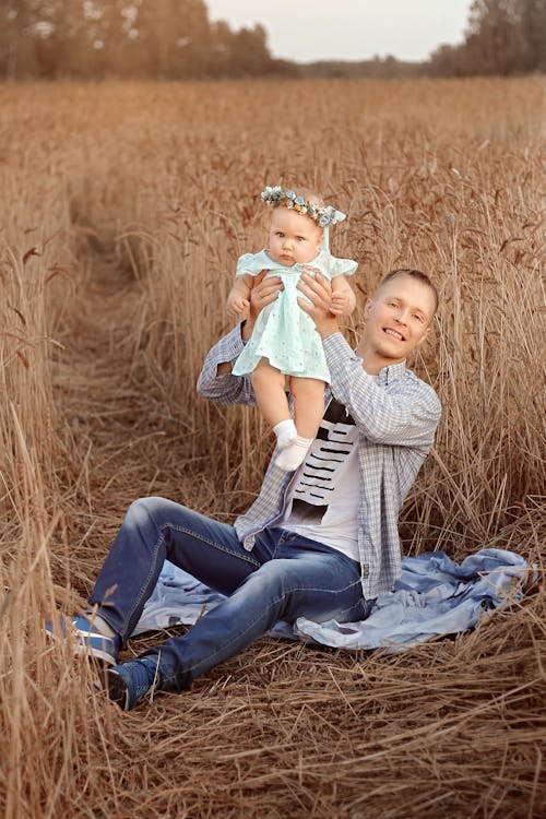 Father and Daughter Sitting on Grass Feild