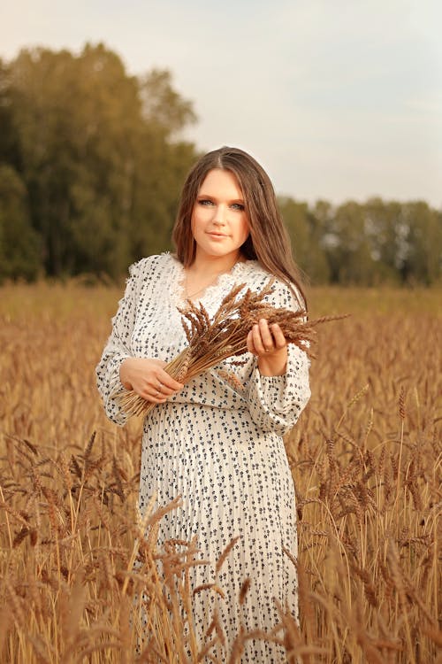 Free Woman in Printed Dress Holding Wheatgrass Stock Photo