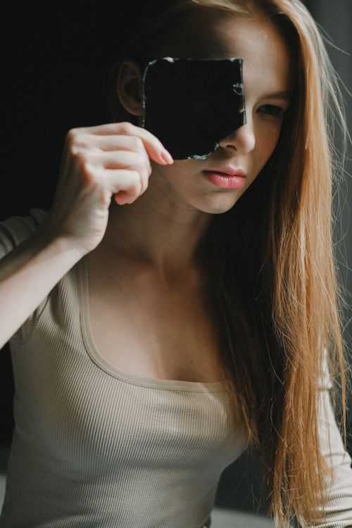 Free Teen girl holding broken glass, creating a modern, introspective portrait. Stock Photo