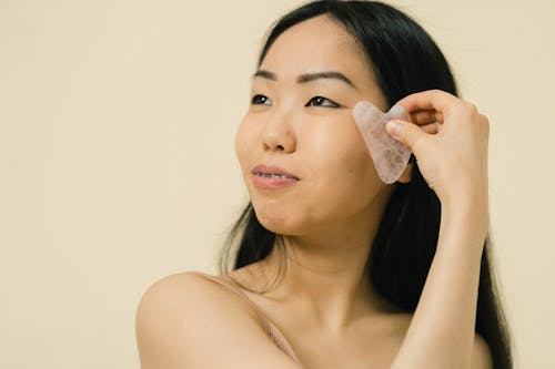 Woman using cosmetic product for facial massage