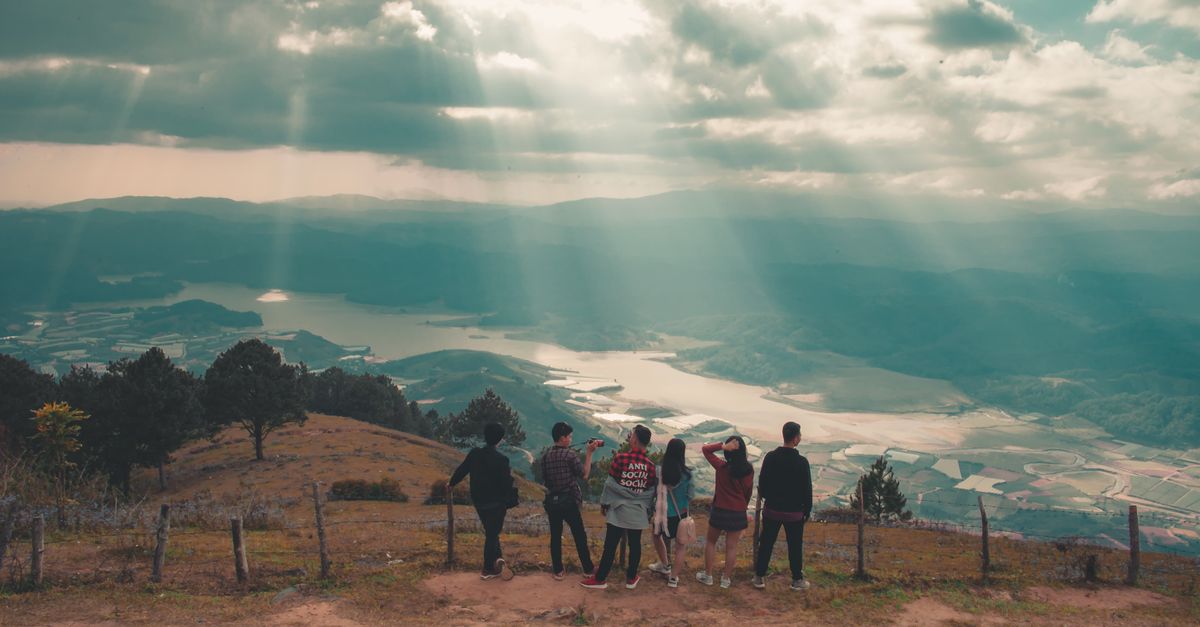 travel influencer teaching a small group photography tips at a scenic viewpoint