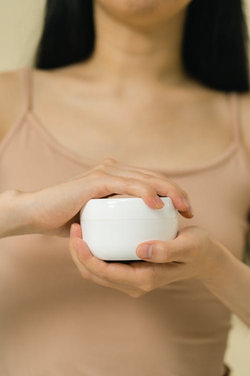 A female holding cosmetic cream 