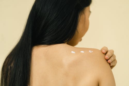 A females shoulder with cosmetic cream on it 