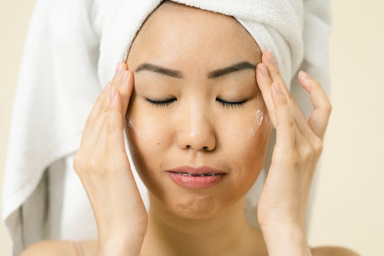 Woman Putting Cosmetic On Her Face