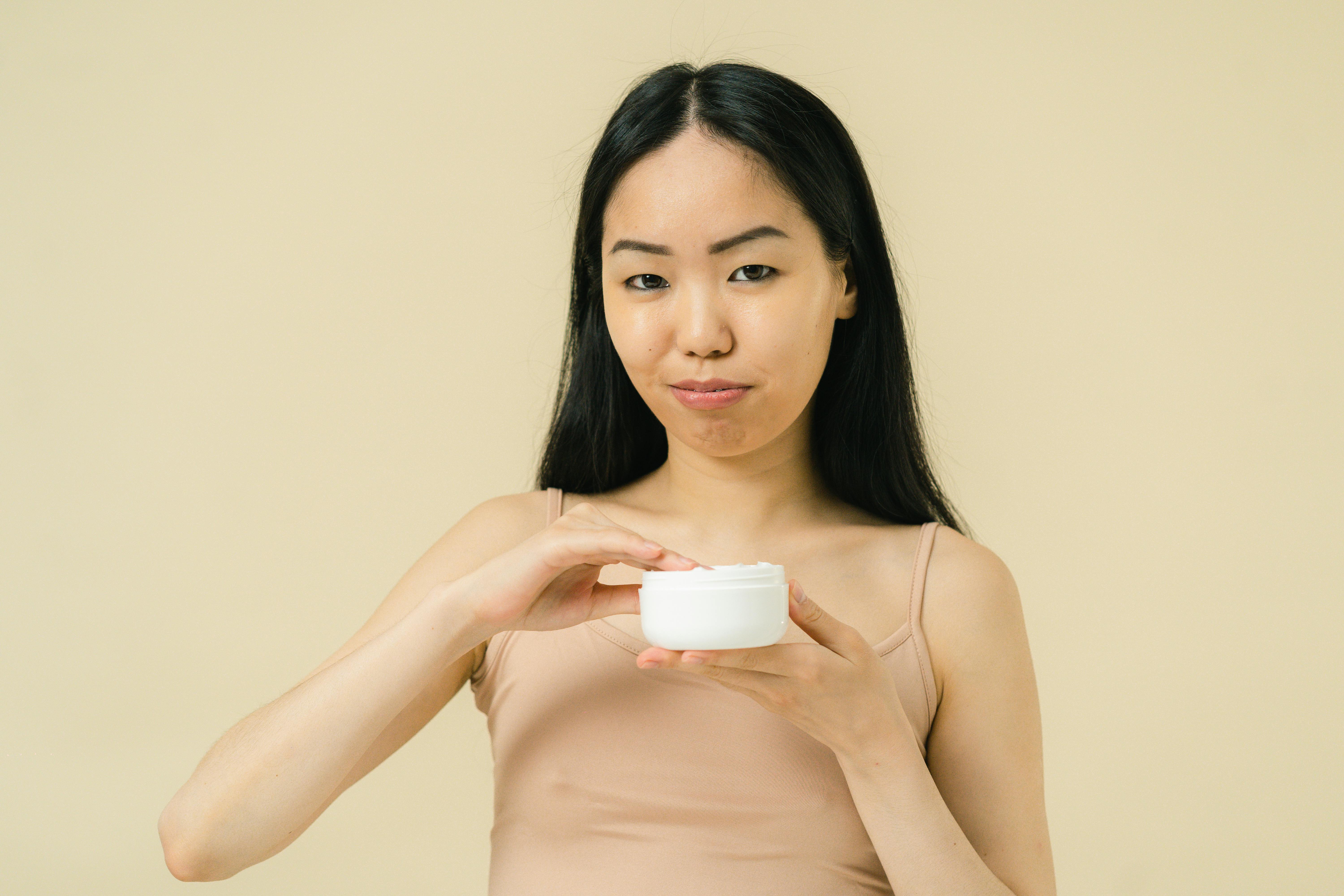 portrait of woman holding cosmetic product