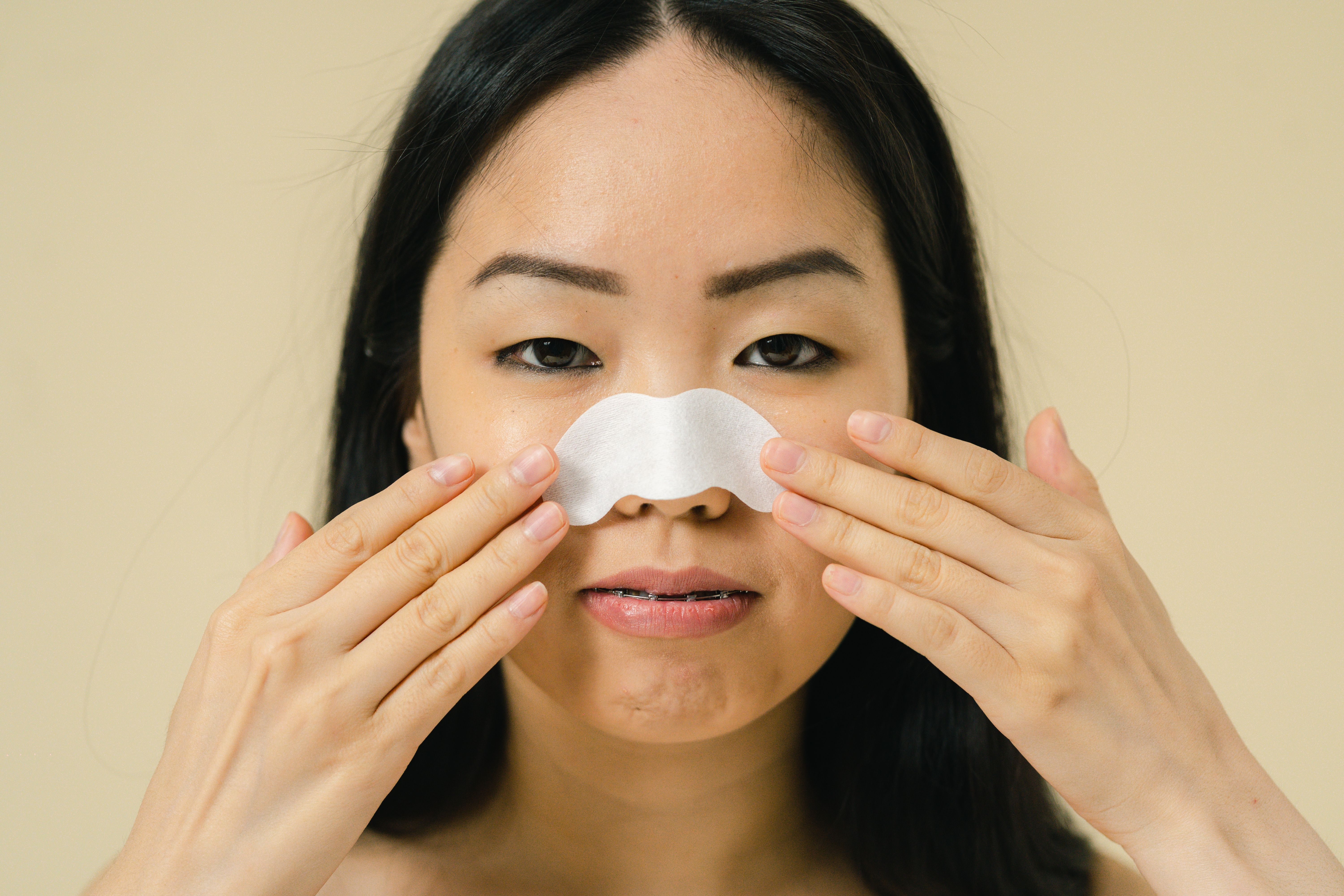 Femme nettoyant son nez avec un produit de soin contre les points noirs