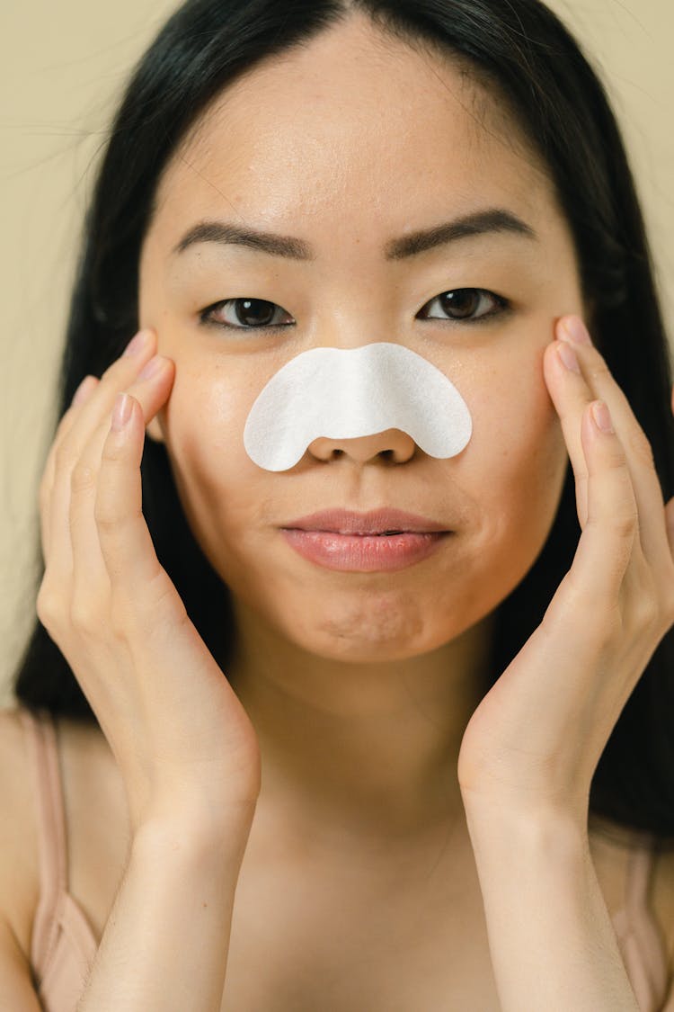 Woman With Cosmetic Mask On Her Nose