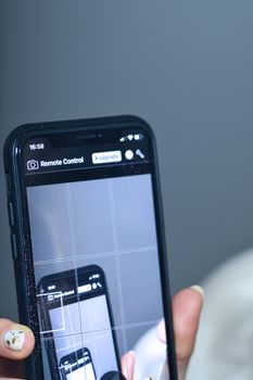 Close-up of hand holding smartphone showing infinity mirrored screen effect.