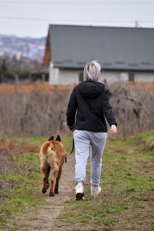 Free Woman Walking with Her Dog Stock Photo