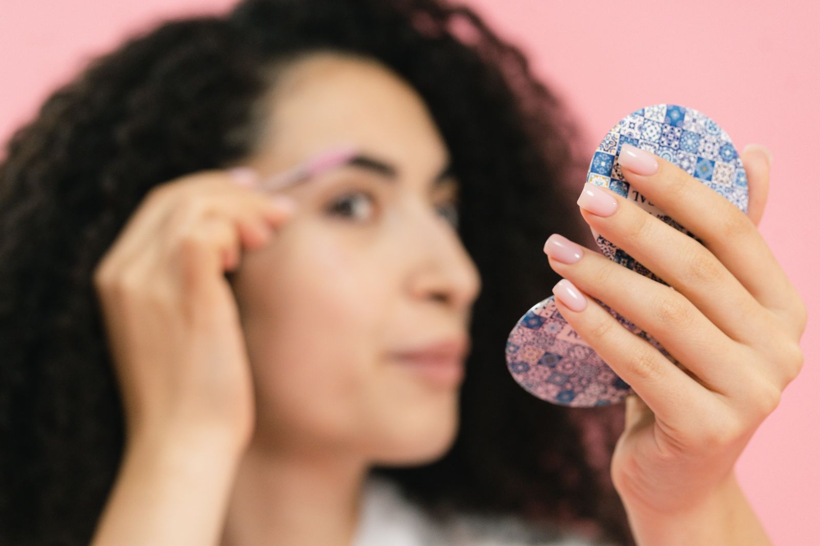 Wedding guest using a compact mirror for makeup touch-ups before an event