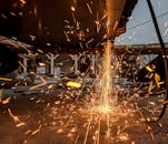 金属加工时，研磨工具喷出充满活力的火花，展现了工业工艺