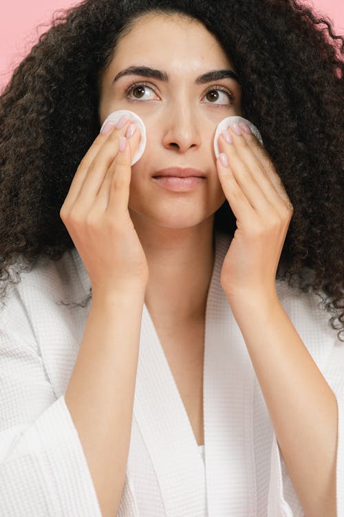 A Woman Holding Cotton Pads on her Face