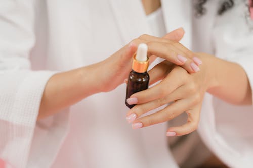 Free A Person Applying Serum on Hands Stock Photo