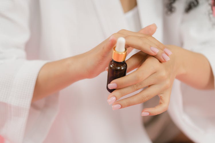 A Person Applying Serum On Hands