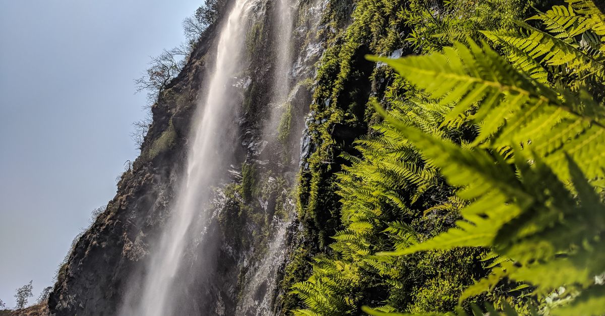 Wli Waterfalls cascading down a lush green cliff face in Ghana's Volta Region