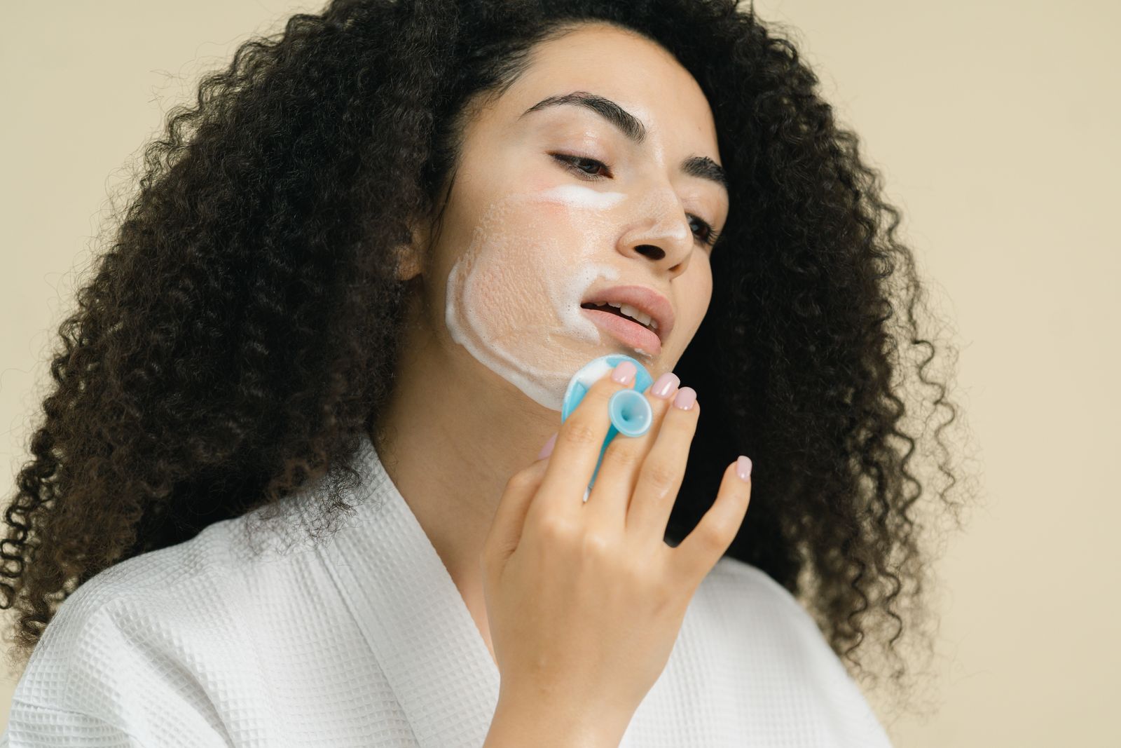 Woman using a facial cleansing brush during an everyday beauty care routine