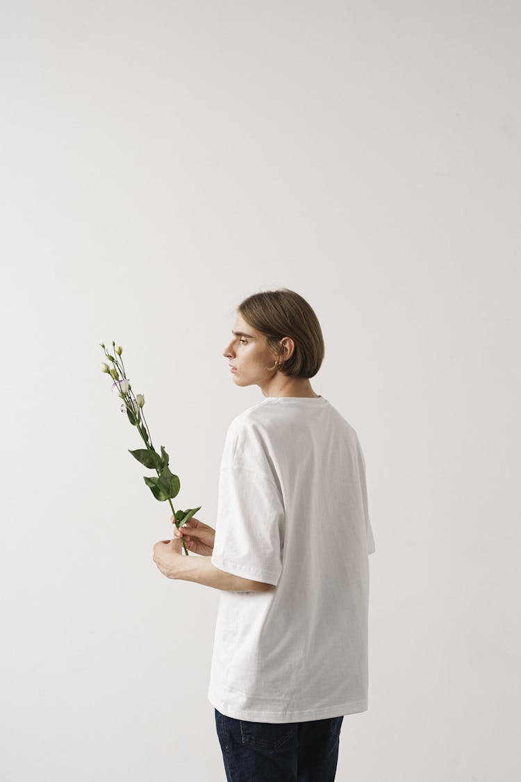 A Man In White Shirt Holding Flowers